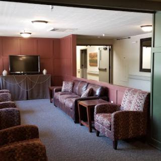 A cozy lounge area featuring comfortable seating and a television, designed for relaxation.