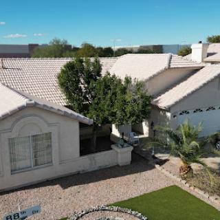 A beautiful residential house with landscaped front yard and clear blue skies.