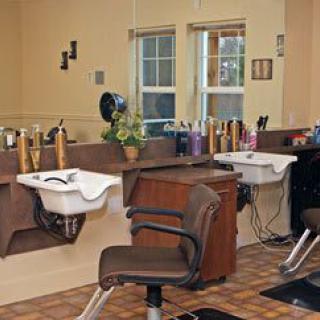 A cozy hair salon interior with styling chairs, mirrors, and washing sinks.