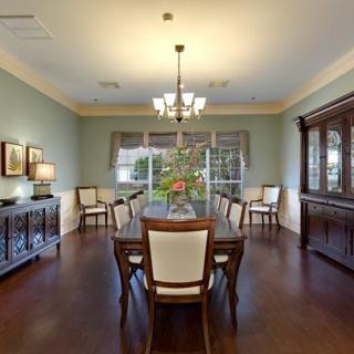 Elegant dining room with classic wooden furniture and a central chandelier.