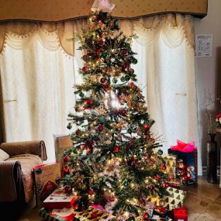A beautifully decorated Christmas tree surrounded by colorful presents, creating a festive atmosphere.