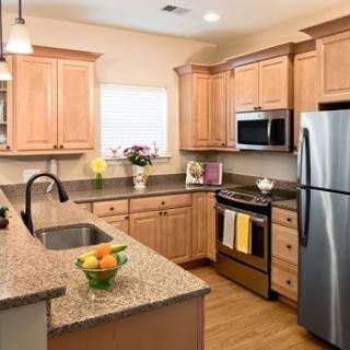 A modern kitchen featuring warm wood cabinets, stainless steel appliances, and a beautiful granite countertop.