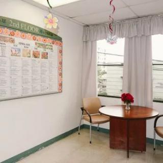 A small waiting area with a round table, two chairs, and a poster on the wall.