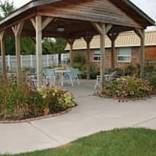 An outdoor gazebo with seating surrounded by a landscaped garden.