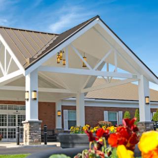 A beautifully designed community center entrance surrounded by vibrant flowers.