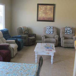 A cozy living room with multiple armchairs and a central coffee table.