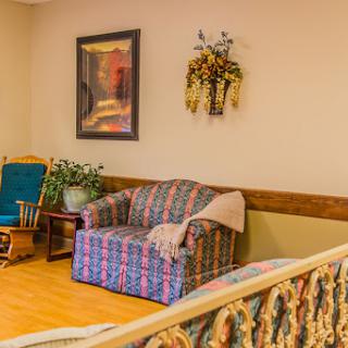 A cozy living room setup featuring a patterned sofa, a rocking chair, and decorative elements.