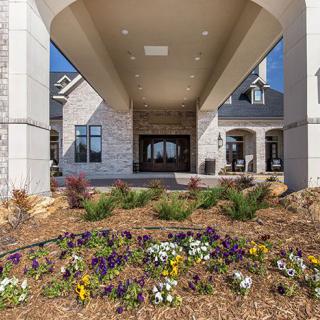 A modern building entrance with landscaped flower beds.