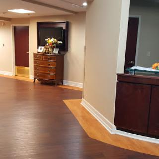 A welcoming office reception area featuring elegant furniture and warm wood flooring.