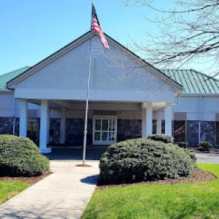 A view of a welcoming building entrance with an American flag waving in the breeze.