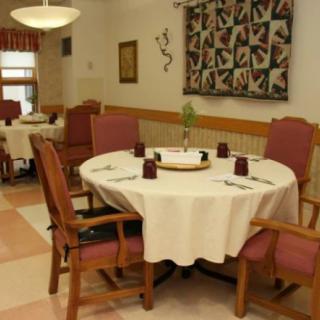 A cozy dining room with a round table set for guests.