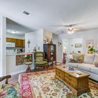 A cozy living room with traditional decor, featuring a comfortable sofa, patterned carpet, and wooden coffee table.