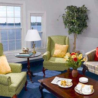 A cozy living room with armchairs and a coffee table by the window.