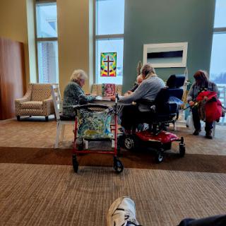 A group of elderly individuals engaging in a social activity at a community center.