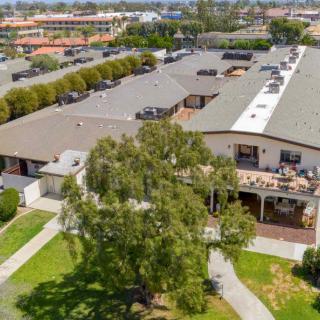 Aerial view of a building surrounded by trees and pathways in a neighborhood setting.