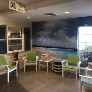 A cozy waiting room with beach-themed decor and comfortable seating.