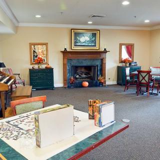 A cozy living room featuring a fireplace, comfortable seating, and decorative artwork.