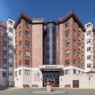 A multi-story building with a prominent entrance, likely serving as a hotel or apartment complex.