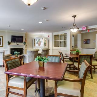 A cozy dining and living area with tables, chairs, and comfortable seating.