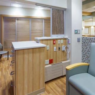 A modern hospital nurse station with wood accents and comfortable seating.