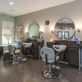 A modern hair salon with stylish decor and comfortable chairs.