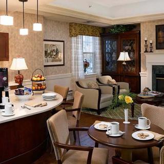 A cozy living room with a dining area featuring traditional decor and warm lighting.
