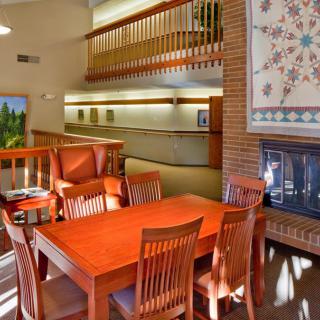 A cozy dining area with wooden furniture and a fireplace, featuring warm lighting and decor.