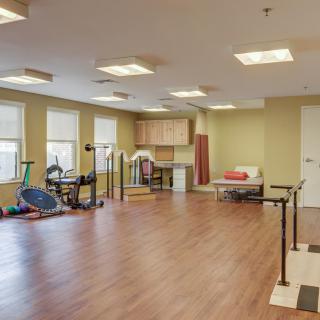 A therapy room equipped with various exercise equipment for rehabilitation and physical therapy.