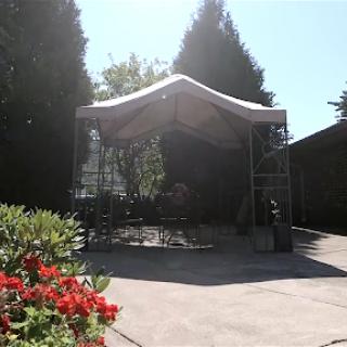 A tranquil outdoor stage surrounded by lush greenery and vibrant flowers.
