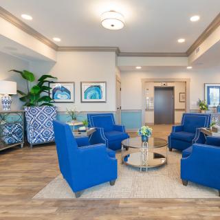 A modern living room with blue chairs and contemporary decor.