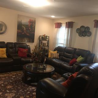 A cozy living room with leather sofas and colorful pillows.