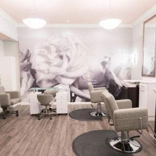 A modern salon interior featuring hairstyling chairs and elegant decor.