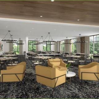 A modern restaurant interior with lounge chairs, tables, and large windows.