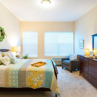 A cozy bedroom with a colorful quilt and stylish decor.