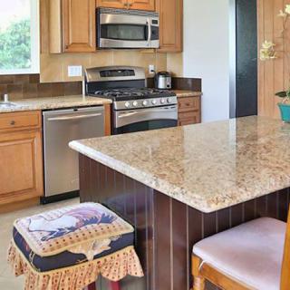 A modern kitchen with granite countertops and stainless steel appliances.