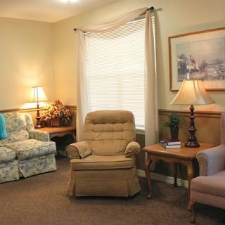 A cozy living room with a sofa, armchairs, and lamps providing a warm atmosphere.
