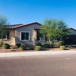 A suburban house surrounded by desert landscaping on a sunny day.