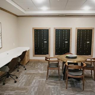 A cozy room featuring a round table with chairs and wine racks on the wall.