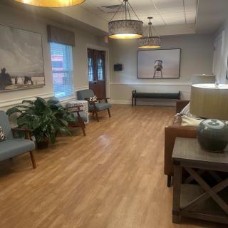 A cozy waiting room with comfortable seating and decorative artwork.