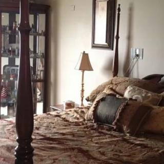 A cozy bedroom with a wooden bed and decorative pillows.