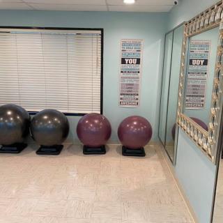 A fitness room with exercise balls and motivational posters.