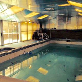 An indoor swimming pool with a sleek, modern design and ample natural lighting.