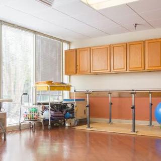 A rehabilitation room equipped with parallel bars and therapy equipment.