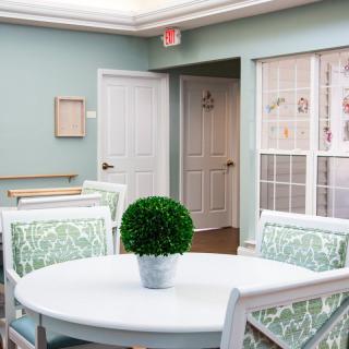 A cozy dining area with a round table and green decor.