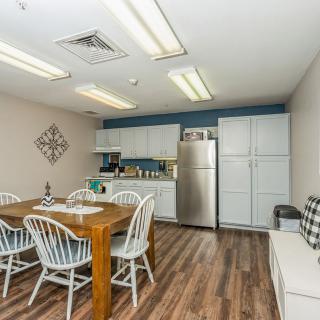 A cozy kitchen and dining area featuring a wooden table with chairs, modern appliances, and ample cabinet space.