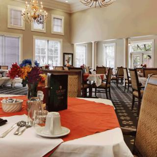 Elegant dining room setup with floral decor and warm lighting.