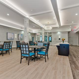 A modern dining area featuring neatly arranged tables and chairs, with elegant lighting and decor.