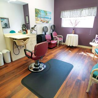 A cozy hair salon with a styling station and comfortable seating.