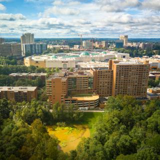 A panoramic view of a bustling urban landscape under a partly cloudy sky.