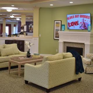 A cozy living room with a sofa set, fireplace, and television displaying 'Los Angeles Love'.